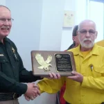 Captain Bob Pruiksma receives the award from Sheriff Jobe