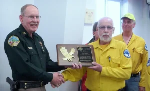 Captain Bob Pruiksma receives the award from Sheriff Jobe